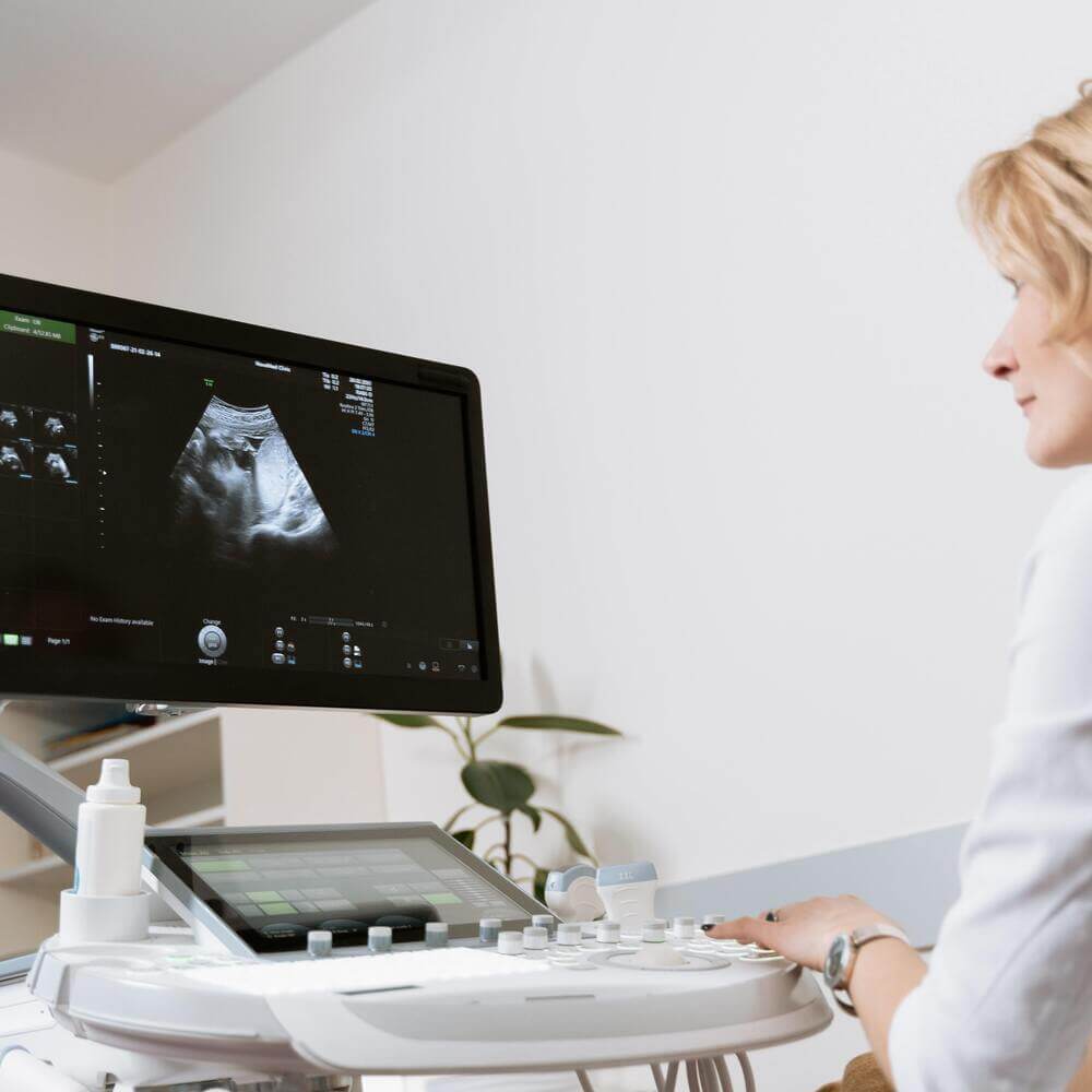Lekarz siedzący przed aparatem usg